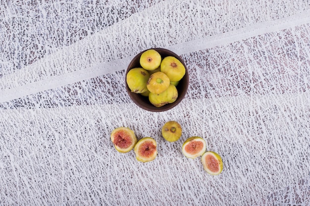 Photo gratuite figues entières et tranchées dans un bol en bois.