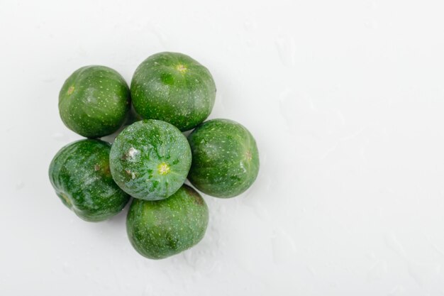 Figues fraîches à plat sur un mur blanc