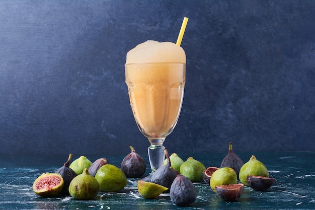 Photo gratuite figues avec une tasse de boisson sur bleu.