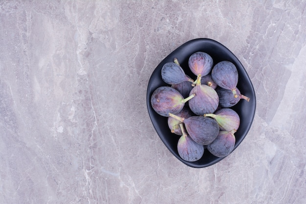 Figues violettes dans un bol en céramique noire.