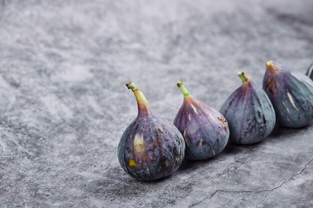 Figues violettes mûres sur une table en marbre.