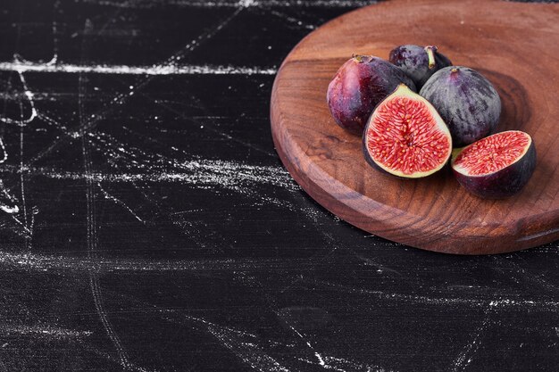 Figues violettes sur un plateau en bois.