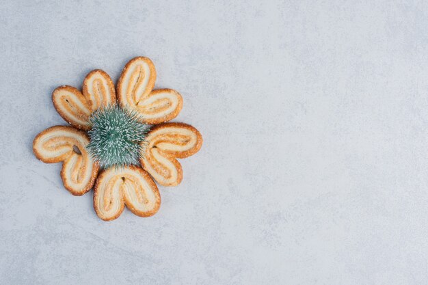 Figurine d'arbre entouré de biscuits feuilletés sur une surface en marbre
