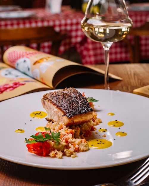 Filet de poisson grillé servi sur le dessus de la salade de couscous aux poivrons verticaux