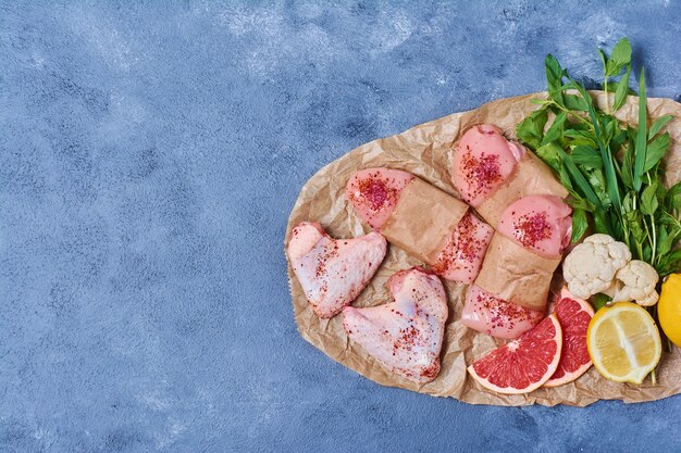 Filet de poulet aux épices sur une planche de bois sur bleu