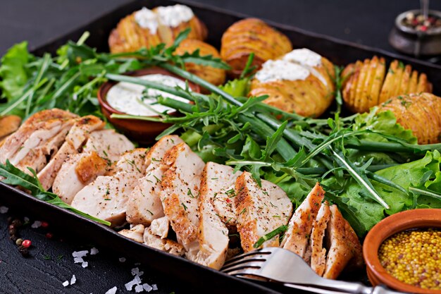 Filet de poulet cuit sur un grill avec une garniture de pommes de terre au four. Repas diététique. Nourriture saine.