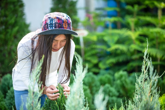 Photo gratuite la fille admire les fleurs dans le jardin.