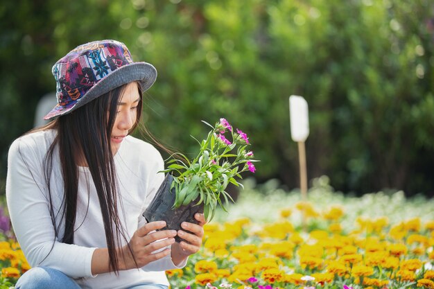 La fille admire les fleurs dans le jardin.