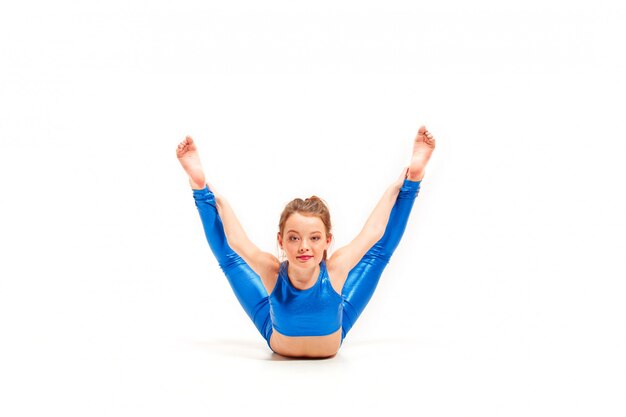 La fille adolescente faisant des exercices de gymnastique isolé sur fond blanc