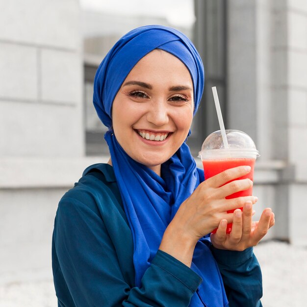 Fille adolescente vêtue de bleu posant avec un smoothie