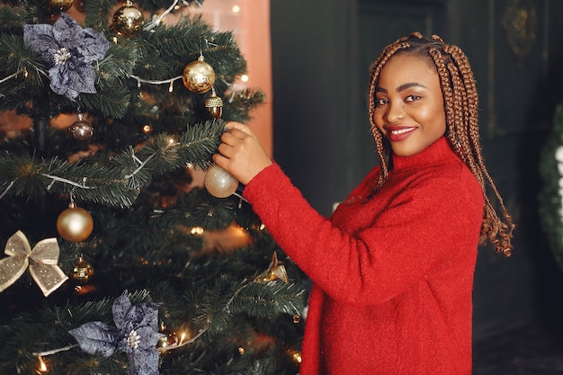 Fille africaine dans une décoration de Noël / femme dans un pull rouge. Concept de nouvel an.