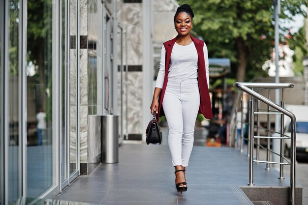 Fille afro-américaine avec sac à main posé à l'extérieur de la ville de steets