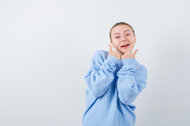 Une fille agréable montre son émotion avec ses doigts sur fond blanc