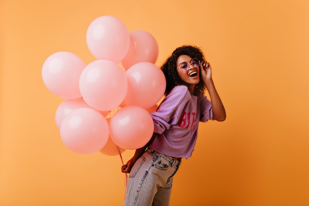 Fille D'anniversaire Enthousiaste En Jeans à La Mode Se Détendre à La Fête. Rire Femme Joyeuse Avec Des Ballons Roses.