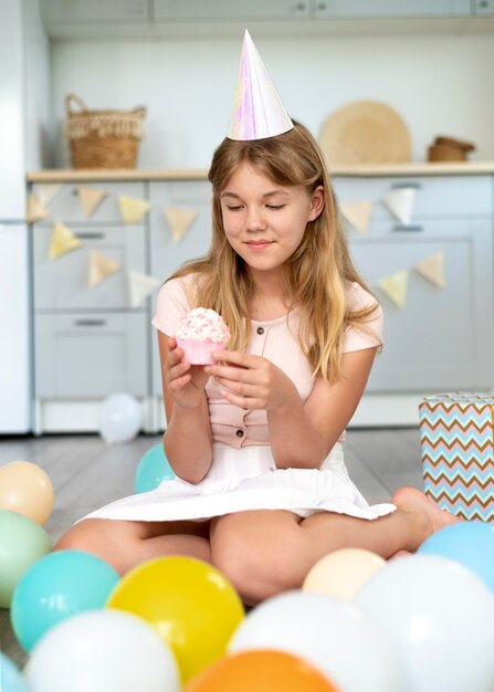 Fille d'anniversaire plein coup tenant un petit gâteau