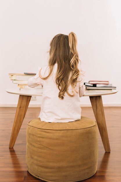 Fille anonyme étudiant à table