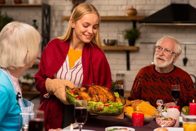 La fille apporte la dinde délicieuse à la table