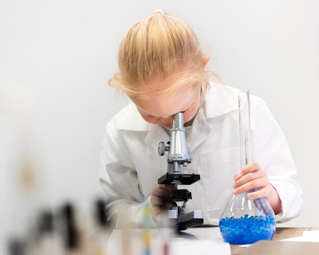 Fille apprenant à faire de la science au microscope