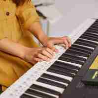 Photo gratuite fille apprenant à jouer du clavier électronique