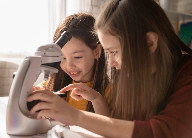 Photo gratuite fille apprenant avec microscope se bouchent