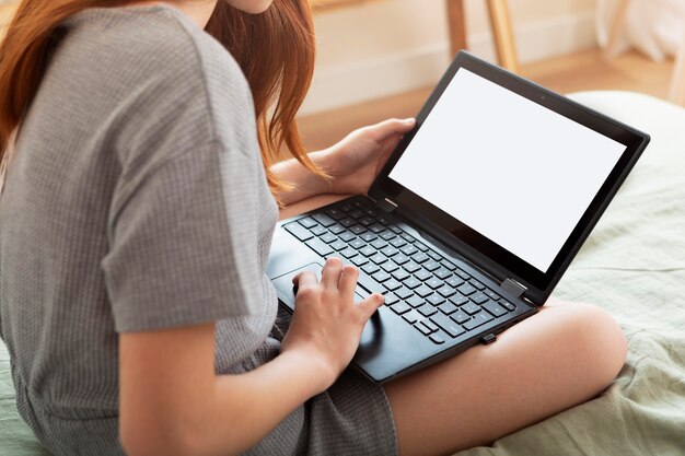 Fille apprenant avec un ordinateur portable à l'intérieur se bouchent