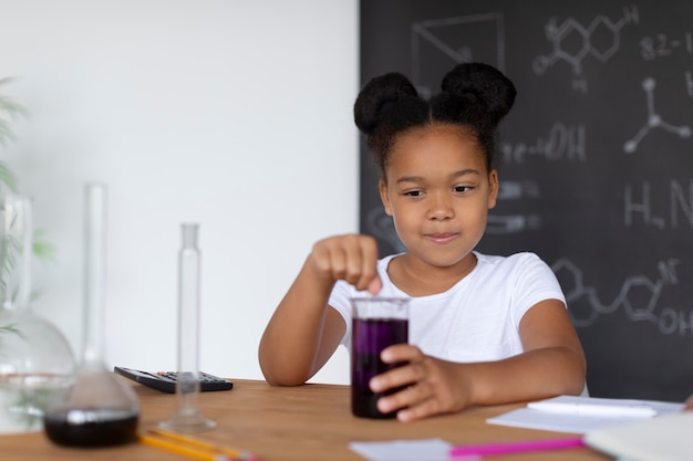 Fille apprenant plus sur la chimie en classe