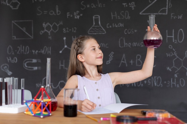 Fille apprenant plus sur la chimie en classe