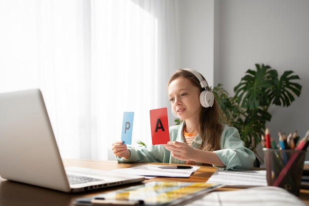 Fille apprenant avec la vue de côté d'ordinateur portable