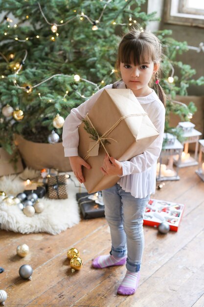 Fille avec arbre de Noël et cadeau