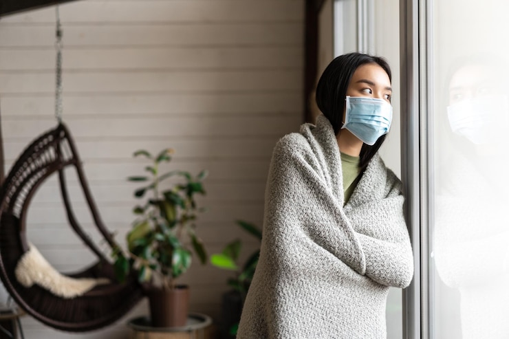 Photo gratuit fille asiatique tombant malade portant un masque médical pour le visage restant en quarantaine covid et regardant à l'extérieur oui...