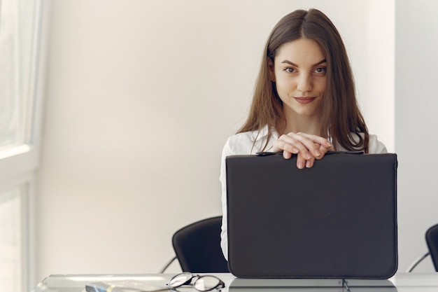 Fille Assise Au Bureau Avec Un Ordinateur Portable