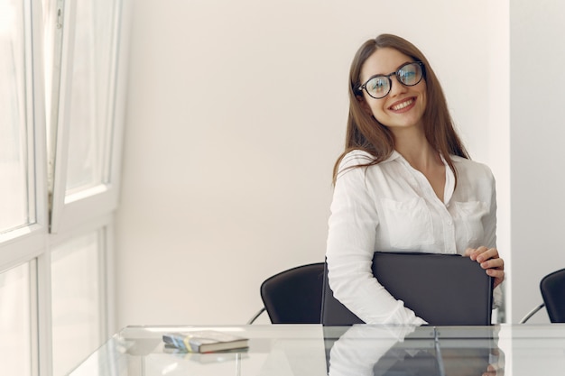 Fille assise au bureau avec un ordinateur portable