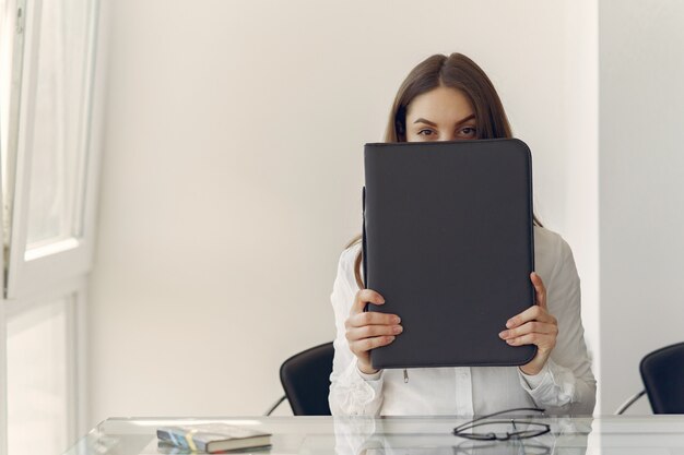 Fille assise au bureau avec un ordinateur portable