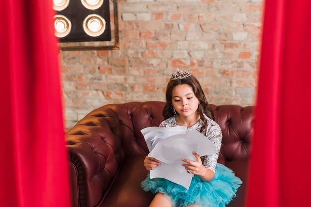 Fille assise aux coulisses