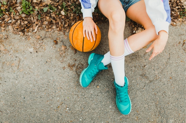 Photo gratuite fille assise avec le basket-ball