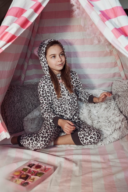 Photo gratuite fille assise à côté d'une boîte de chocolat et à l'écart