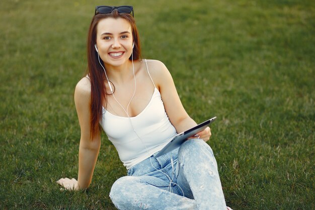 Fille assise dans un campus universitaire à l'aide d'une tablette