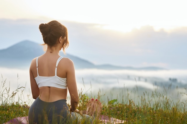 Fille assise sur les jambes dans les montagnes