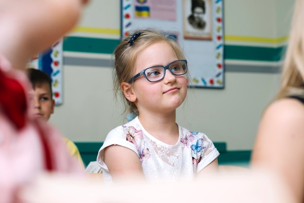 Photo gratuite fille assise à la leçon avec ses camarades de classe