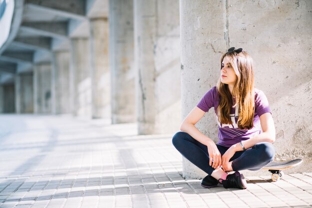 Fille assise sur un skateboard