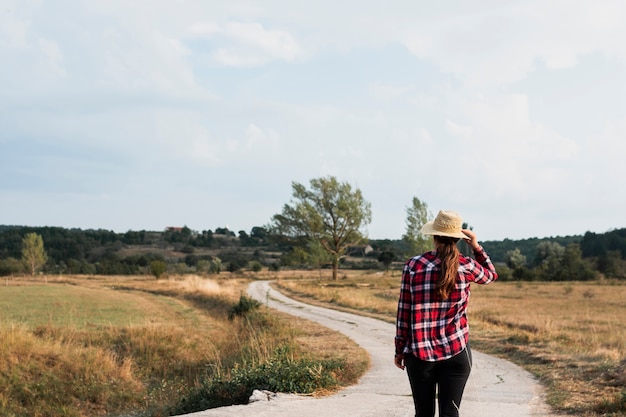 Fille au bord d'une route de campagne