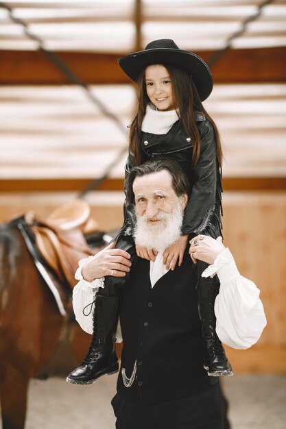 Fille au casque Apprentissage de l'équitation. L'instructeur enseigne à la petite fille.