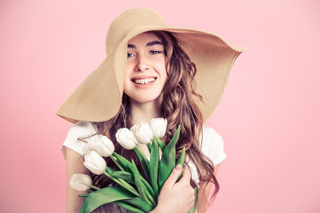 fille au chapeau et tulipes sur un mur coloré