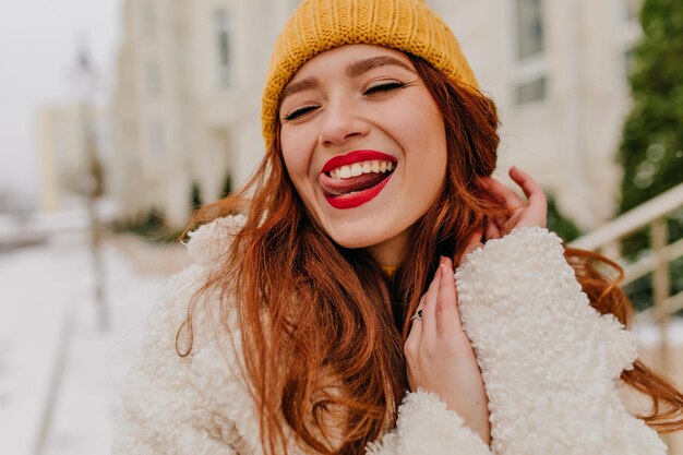 Une fille au gingembre raffinée porte un chapeau jaune en hiver