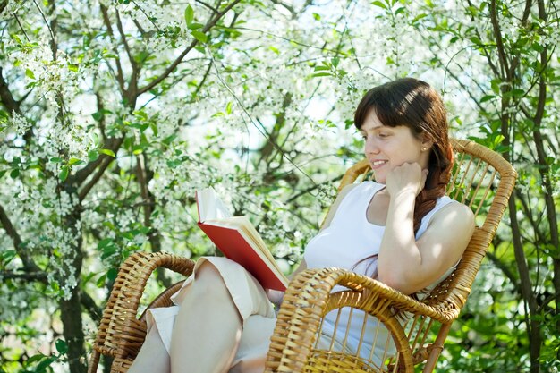 Fille au jardin fleurissant au printemps