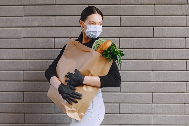 Fille Au Masque De Protection Détient Le Paquet De Produits