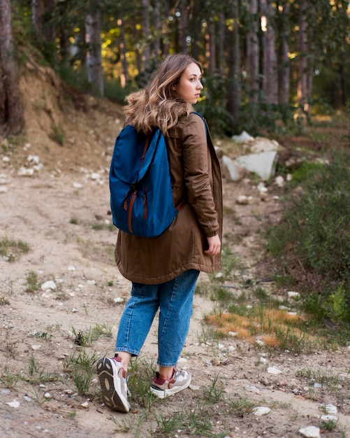 Photo gratuite fille aux cheveux bruns tir complet en forêt