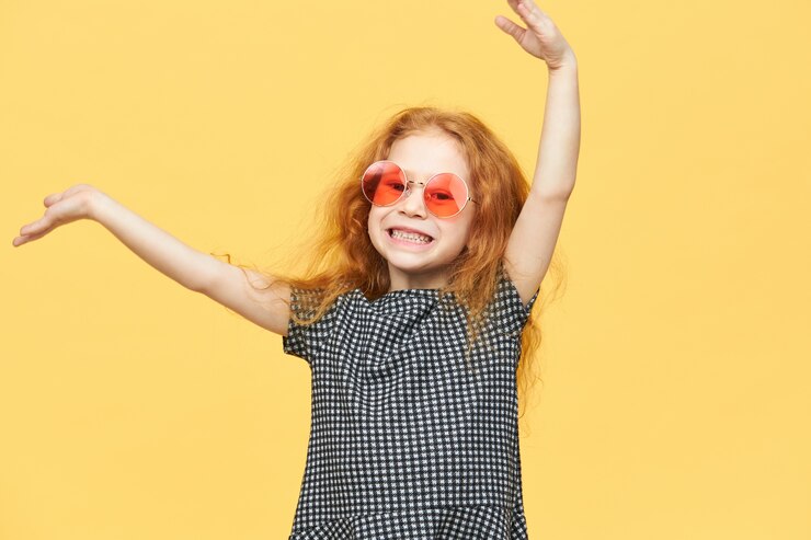 Photo gratuit fille aux cheveux roux avec une robe noire et blanche et des lunettes de soleil