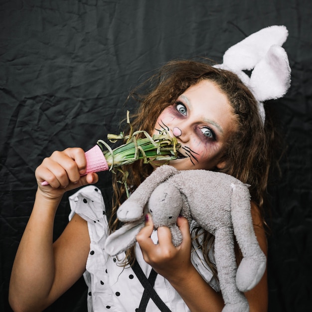 Photo gratuite fille aux oreilles de lapin, manger de l'oignon vert