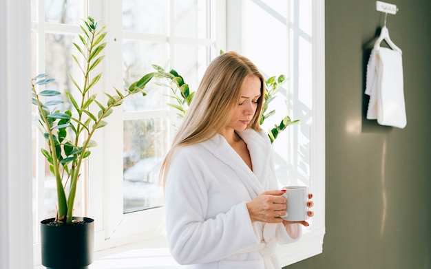 Fille ayant un café à la salle de bain